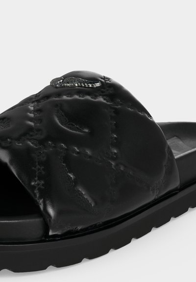 Μαύρο σανδάλι με φάσα, με ανάγλυφο και ραμμένο δερμάτινο πάνω μέρος και μεταλλική διακοσμητική λεπτομέρεια σε σχήμα κροκόδειλου στην κορυφή.
