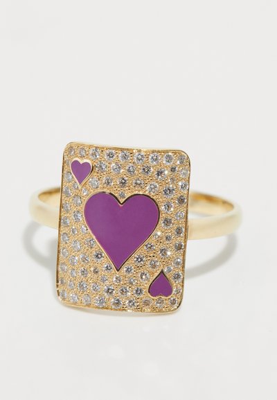 Goldfarbener Ring mit rechteckigem Design, das mit lila Herzformen und umgebenden klaren Kristallen verziert ist. Glatte Band mit strukturiertem Detail.