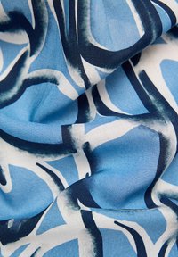 Blau- und weißer Stoff mit abstrakten, fließenden Formen in Dunkelblau und Teal. Die Textur wirkt glatt mit einem leichten Glanz.