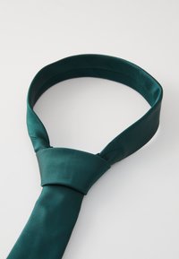 Corbata de seda en color azul verdoso con una textura suave, que presenta un diseño de nudo clásico, que se estrecha hasta un punto. Color sólido y simple sin patrones.