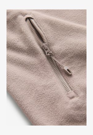 Fleece-Pullover in Beige mit strukturierter Oberfläche, ausgestattet mit einem Viertel-Reißverschluss und passendem Reißverschluss-Zipper. Weicher, warmer Stoff, der ideal zum Layering geeignet ist.