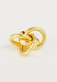Goldfarbener Metallring mit miteinander verbundenen Schlaufen, der eine glatte, glänzende Oberfläche aufweist. Skulpturales Design mit drei ausgeprägten kreisförmigen Formen.