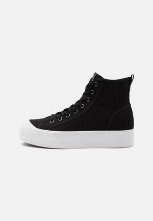 Zapatilla alta negra con suela gruesa de goma blanca, cordones negros, ojales de metal y patrón sutilmente texturizado en la parte superior de tela.