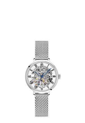 Montre-bracelet argentée avec bracelet en maille, cadran transparent montrant les engrenages, aiguilles bleues et index horaires en chiffres romains noirs.