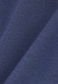 Tiefblauer Stoff mit strukturierter Oberfläche. Die Fasern sind eng gewebt, wodurch eine glatte und dennoch strapazierfähige Optik entsteht.