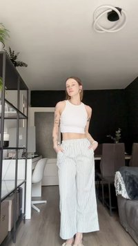 Vitt crop-top som kombineras med vida randiga byxor i ljusgrön och vit. Byxorna har sidofickor och en avslappnad passform.