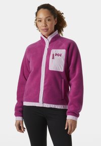 Fleece jack in felroze met lichtroze contrasterende randen, voorzien van een ritszak, drukknoopsluiting en een gestructureerde kraag.