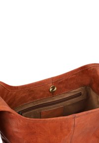 Tan leather handbag with a soft texture, open top, interior zip pocket, and brass snap closure. Features visible stitching detail.