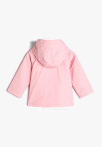 Chaqueta con capucha rosa, de manga larga, textura suave y diseño sencillo. La vista trasera muestra una costura curva a lo largo de la capucha.