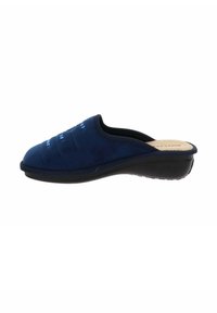 Zoccoli blu navy slip-on con tomaia in tessuto morbido, silhouette curva e suola in gomma nera. Presentano un delicato ricamo lungo la parte superiore.