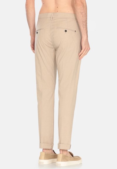 Pantaloni beige chiaro con una vestibilità slim, caratterizzati da una superficie liscia, due tasche posteriori con bottoni neri e orli arrotolati.