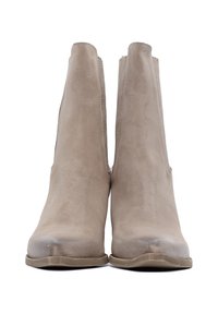 Stivaletti ankle in suede beige con una texture liscia, suola in gomma piatta e pannelli elastici laterali. Forma della punta arrotondata con un design a profilo basso.