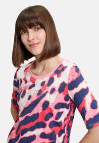 Short-sleeve T-shirt featuring a pink and blue abstract animal print, round neckline, and embellished text "HAPPY" with rhinestones.