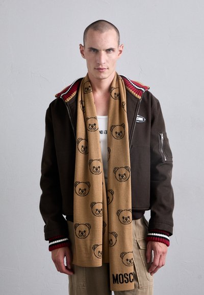 Pruun tõmblukk-k jacket, millel on triibuline krae, beež sall mustade karu printidega ja "MOSCHINO" logo. Tekstuuritud kangas, igapäevane disain.
