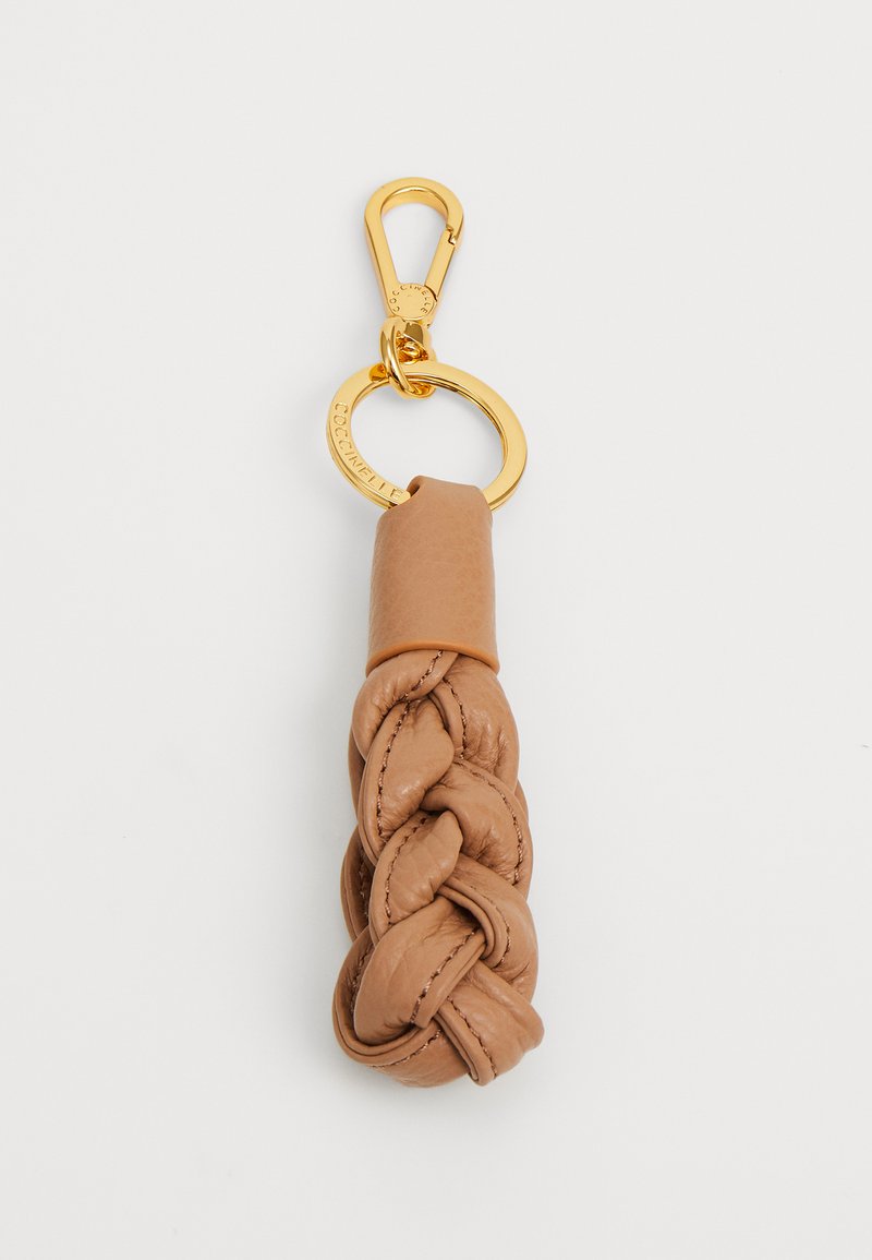 Porte-clés tressé en cuir brun clair, avec une finition texturée et un clip en métal doré pour l'attache. Compact et lisse.