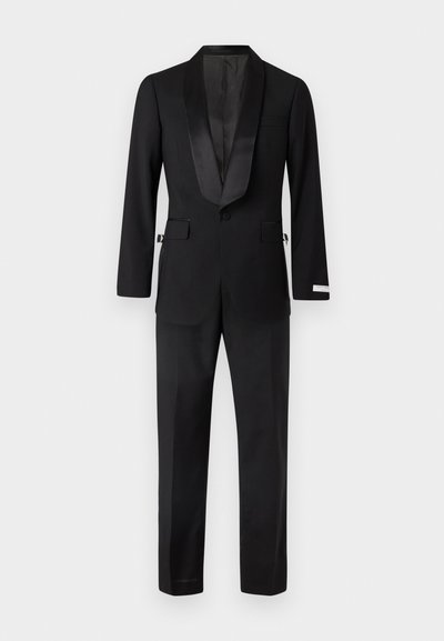 Černý smoking s saténovým špicatým klopem, strukturovanými rameny a upravenými kalhotami se bočními kapsami a slim fit střihem.