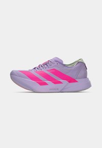Leichter Laufschuh in Lavendel mit auffälligem pinkfarbenem Drei-Streifen-Design. Merkmale sind ein glattes Obermaterial, eine gepolsterte Sohle und ein minimalistischer Stil.