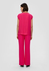 Top senza maniche rosa e pantaloni larghi abbinati. Tessuto morbido con una vestibilità rilassata. Il top presenta una scollatura semplice; i pantaloni hanno un design lungo e fluido.