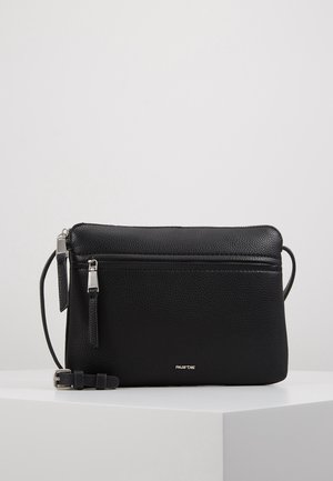 Czarna torebka na ramię z teksturowanej skóry, z srebrnymi zamkami błyskawicznymi i regulowanym paskiem, umieszczona na białej powierzchni na jednolitym tle.