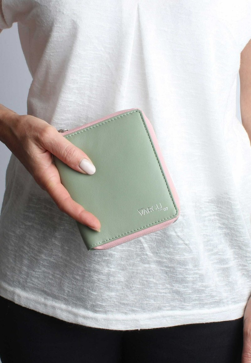 Green and pink leather wallet with a zip closure, rectangular shape, and embossed brand name on the front. Smooth texture, compact design.