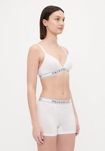 A fehér pamut bralette és sort szett sima textúrával, háromszög alakú kosarakkal és "POLO RALPH LAUREN" logós elasztikus pánttal rendelkezik.