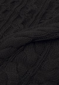 Tissu en tricot noir avec un motif de câble texturé, fait de fil épais et affichant une apparence douce et moelleuse.