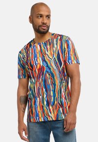 Multifarvet T-shirt med korte ærmer og et levende bølgemønster i blå, rød, gul og grøn, lavet af et glat stof.