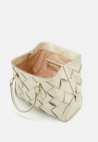 Cream woven leather handbag with dual handles, open top showing beige suede interior and a small zippered pocket inside.
