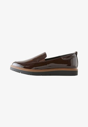 Brown patent leather slip-on shoe with black thick sole and tan welt, side view.