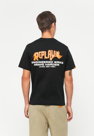 Black T-shirt featuring oversized orange "REPLAY INC" logo and text on the back, short sleeves, and a standard fit.