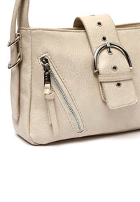 Beige faux leather shoulder bag with a textured finish, featuring a side zipper pocket, a wide strap with belt-like accents, and metal hardware.