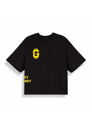 Maglietta nera oversize con simbolo "G" pixelato giallo sul petto e testo giallo parzialmente visibile "GET MONEY" vicino all'orlo.
