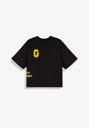 Camiseta negra de gran tamaño con símbolo "G" pixelado en amarillo en el pecho y texto amarillo parcialmente visible "GET MONEY" cerca del dobladillo.