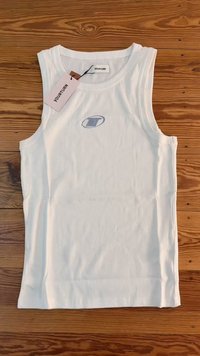Witte geribbelde tanktop met een ronde halslijn, dikke bandjes en een klein blauw logo op de voorkant. Etiket bevestigd met de merknaam "YOURTURN."
