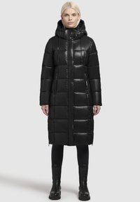 Black puffer coat with a hood, featuring a quilted design, front zipper, and side pockets. Made from shiny, smooth material.