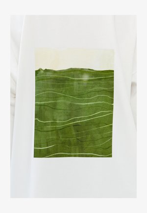 Maglietta bianca con una grafica rettangolare di un paesaggio verde caratterizzata da onde testurizzate e dettagli verde chiaro su uno sfondo pallido.