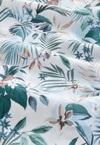 Tessuto floreale con foglie verdi e fiori blu su uno sfondo azzurro chiaro. Texture liscia con illustrazioni botaniche dettagliate.