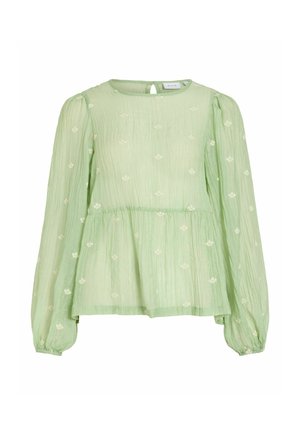 Blouse vert clair à manches longues avec petits motifs floraux blancs, col rond, taille légèrement froncée et poignets élastiques.