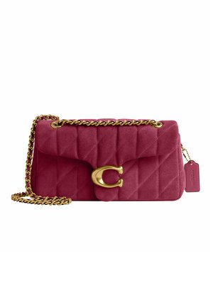 Petit sac à main en daim bordeaux matelassé avec une bandoulière chaîne dorée, une grande fermeture dorée et une étiquette bordeaux assortie suspendue sur le côté.