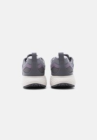 Ζευγάρι αθλητικών παπουτσιών σε γκρι και μοβ χρώμα, απεικονισμένα από πίσω, με λευκές υφασμένες μεσαίες σόλες και μαύρες λαστιχένιες εξωτερικές σόλες σε λευκό φόντο.