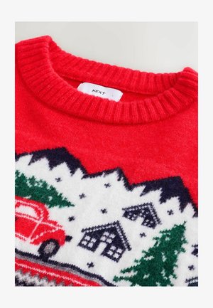 Rød strikket sweater med ribbet halsudskæring, der har et festligt vinterdesign med træer, huse og en rød lastbil på en hvid baggrund.