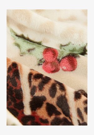 Koc polarowy z kremowym tłem, ozdobiony czerwonymi jagodami i zielonymi liśćmi po jednej stronie oraz brązowym wzorem w panterkę po drugiej.