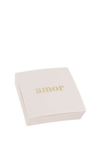 Scatola di gioielli bianca con il testo dorato "amor" centrato sul coperchio, su uno sfondo bianco.