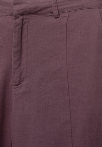 Mauve kalhoty vyrobené z texturované tkaniny, s plochým předním dílem, bočními kapsami a pečlivě zpracovanými švy. Moderní design s přiléhavým střihem.