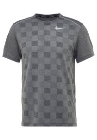 Šedé tričko s krátkým rukávem s kostkovaným vzorem, vyrobené z texturované tkaniny. Obsahuje malé reflexní logo Nike na hrudi.