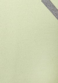 Tissu tricoté vert clair avec une bande diagonale gris foncé pailletée dans le coin supérieur droit.