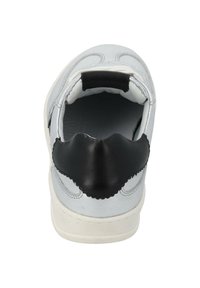 Weiße Leder-Sneaker mit einem schwarzen Lederakzent an der Ferse, geschwungenen Nähdetails und einer strukturierten Oberfläche. Gerundete Form, minimalistisches Design.