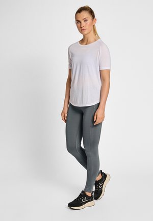 Weißes kurzärmliges Sportshirt, eng anliegende graue Leggings und schwarze Turnschuhe mit beigen Akzenten. Glatte Textur, leichtes Material.