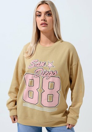 Khaki oversized sweatshirt featuring "San Diego" in pink script above the number "88," with white stripes at the bottom and ribbed cuffs.