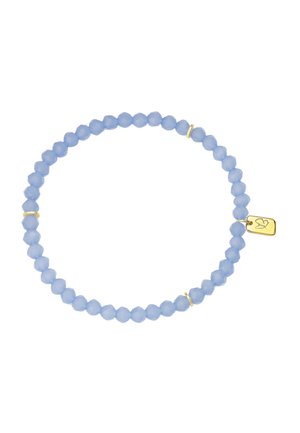 Bracelet extensible avec de petites perles rondes facettées bleu clair, trois anneaux intercalaires dorés et une étiquette dorée avec une gravure d’oiseau.